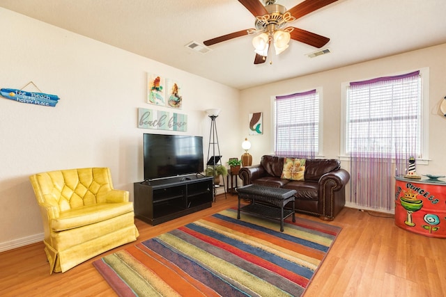 living room with wood finished floors, a ceiling fan, and visible vents
