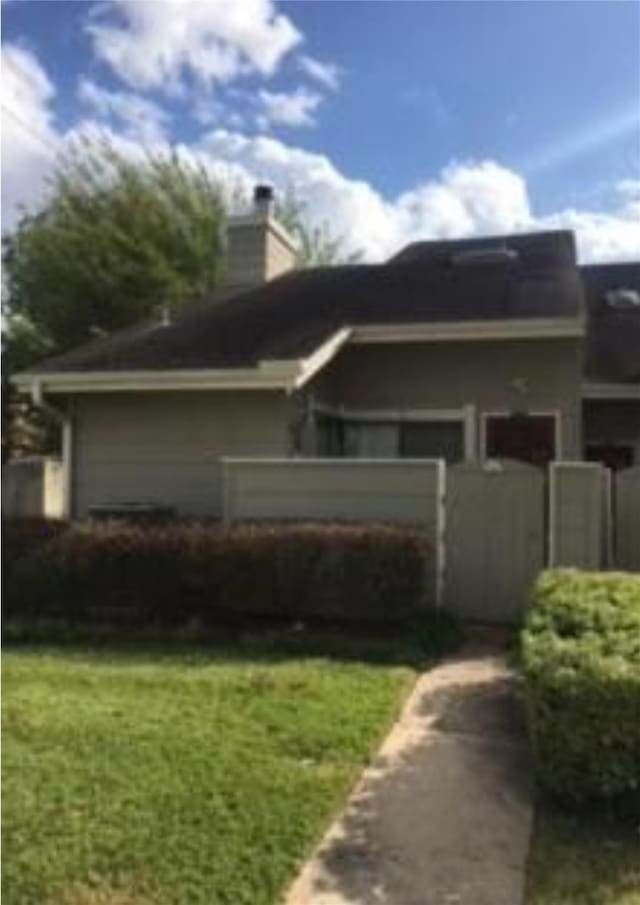 7111 Brendam Ln, Houston, TX 77072 - view of property exterior featuring a chimney, a lawn, and a fenced front yard