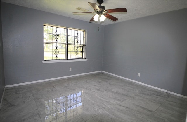 unfurnished room with visible vents, a ceiling fan, baseboards, and a textured ceiling