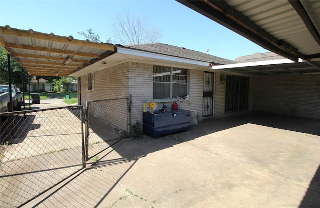 exterior space with a gate, driveway, a carport, and fence