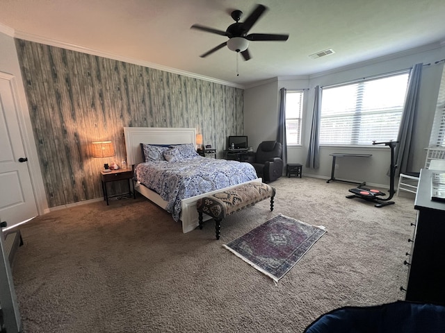carpeted bedroom with visible vents, ornamental molding, baseboards, and ceiling fan