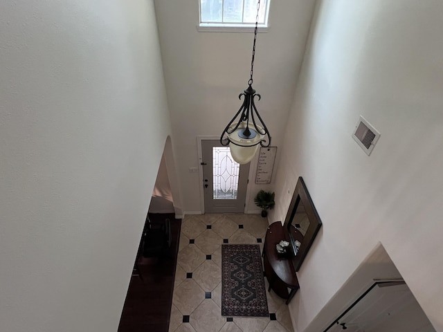 entryway featuring visible vents, tile patterned flooring, and a high ceiling