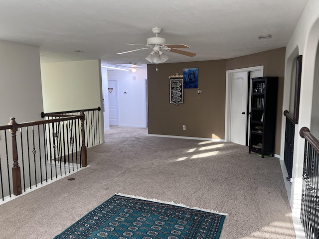 interior space featuring visible vents, carpet flooring, baseboards, and an upstairs landing
