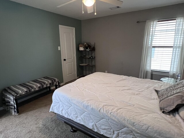 carpeted bedroom featuring ceiling fan and visible vents