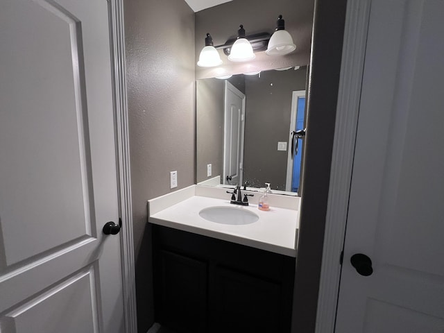 bathroom featuring vanity and a textured wall