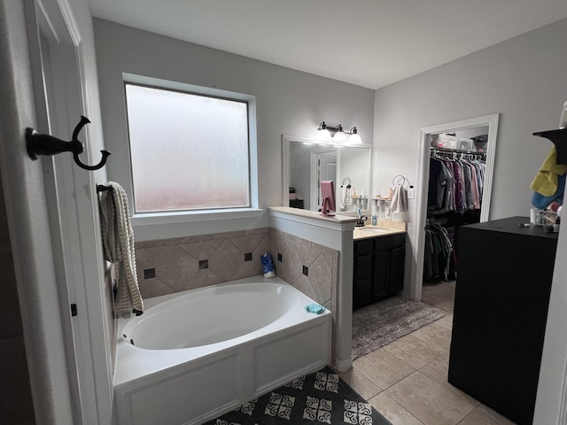 full bath featuring vanity, a bath, tile patterned floors, and a spacious closet