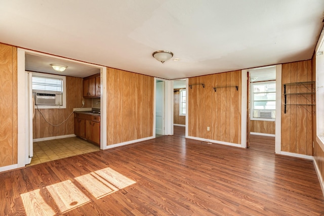 11213 Schwartz Dr, Galveston, TX 77554 - unfurnished living room with cooling unit, wood finished floors, wooden walls, and baseboards