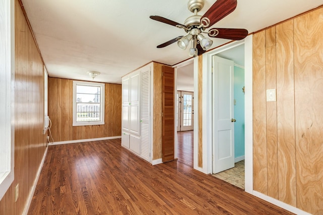 11213 Schwartz Dr, Galveston, TX 77554 - empty room with wood finished floors, wood walls, baseboards, and a ceiling fan