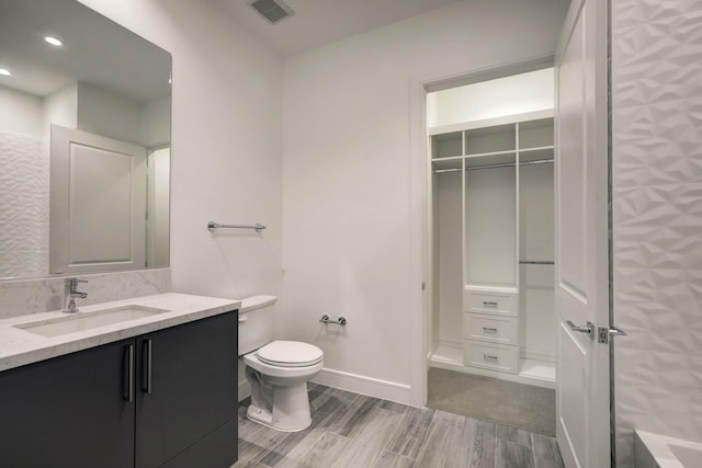 4521 San Felipe St Unit 2304-5, Houston, TX 77027 - full bathroom featuring visible vents, wood finished floors, vanity, toilet, and recessed lighting