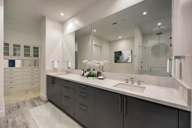 4521 San Felipe St Unit 2304-5, Houston, TX 77027 - bathroom with double vanity, a sink, wood finished floors, and a stall shower