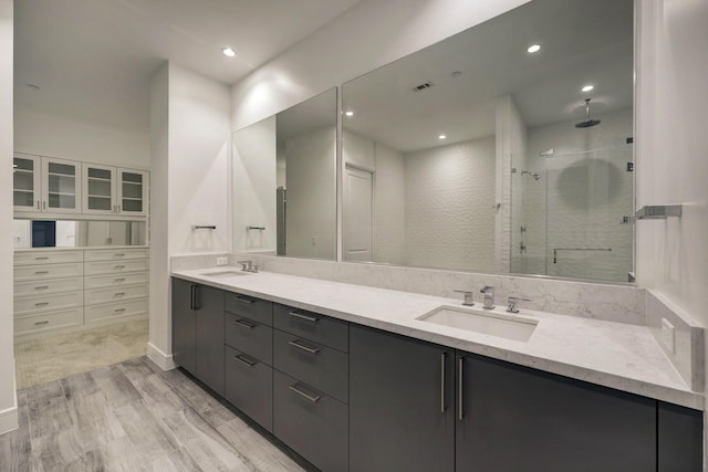 4521 San Felipe St Unit 2304-5, Houston, TX 77027 - full bathroom with double vanity, a shower stall, a sink, and wood finished floors