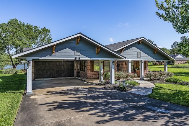 view of front of house with brick siding, an attached garage, driveway, and a front lawn