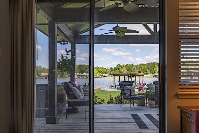 doorway to outside featuring wood finished floors, a water view, and a ceiling fan