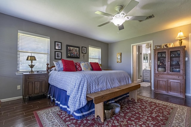 bedroom featuring visible vents, ensuite bath, baseboards, wood finish floors, and ceiling fan