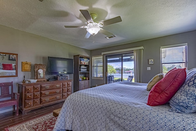 bedroom with a textured ceiling, visible vents, a ceiling fan, and access to outside