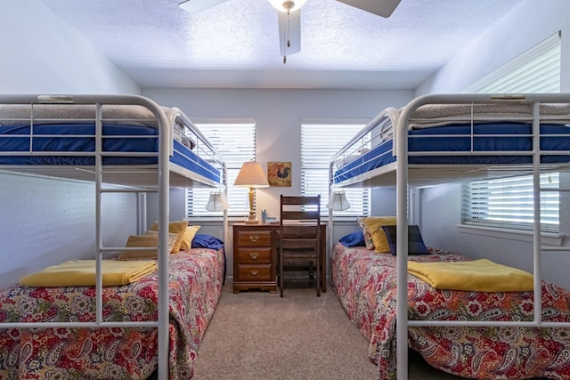 bedroom with a ceiling fan, carpet flooring, and a textured ceiling