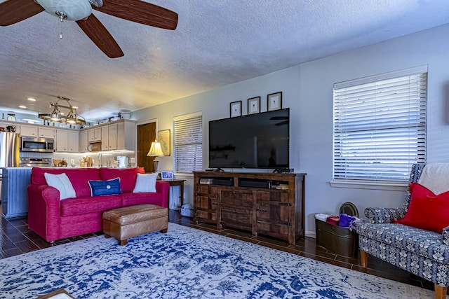 living area with a textured ceiling and a ceiling fan