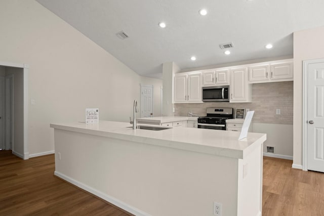 17311 Lowick St, Spring, TX 77379 - kitchen featuring stainless steel appliances, a sink, tasteful backsplash, white cabinets, and light wood-style flooring