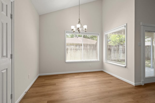 17311 Lowick St, Spring, TX 77379 - unfurnished dining area with a chandelier, light wood-style flooring, baseboards, and high vaulted ceiling