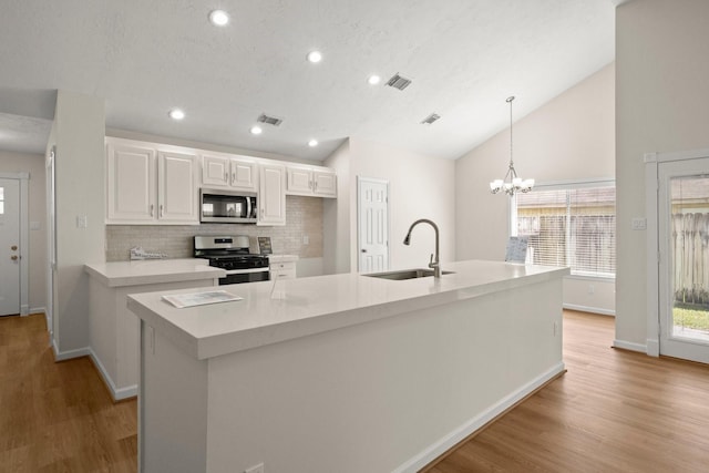 17311 Lowick St, Spring, TX 77379 - kitchen with appliances with stainless steel finishes, a sink, lofted ceiling, white cabinetry, and tasteful backsplash