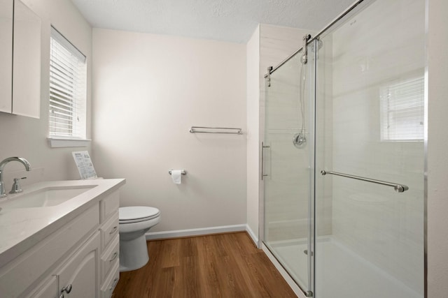 17311 Lowick St, Spring, TX 77379 - bathroom featuring wood finished floors, a shower stall, toilet, vanity, and baseboards