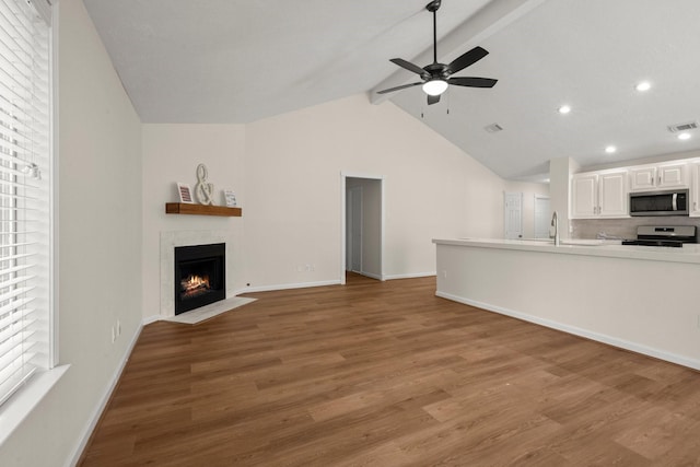 17311 Lowick St, Spring, TX 77379 - unfurnished living room with a ceiling fan, wood finished floors, a fireplace with flush hearth, baseboards, and a sink