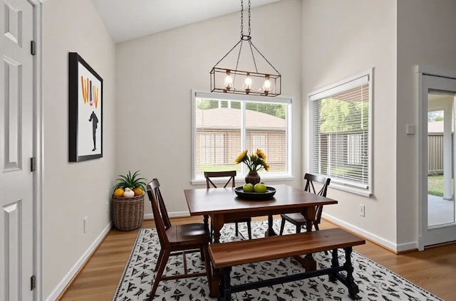 17311 Lowick St, Spring, TX 77379 - dining space featuring light wood-style floors, a chandelier, baseboards, and vaulted ceiling
