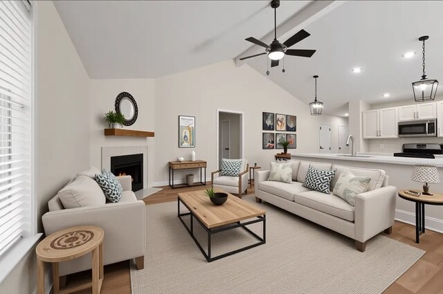 17311 Lowick St, Spring, TX 77379 - living room featuring a ceiling fan, a tiled fireplace, light wood-style flooring, beamed ceiling, and recessed lighting