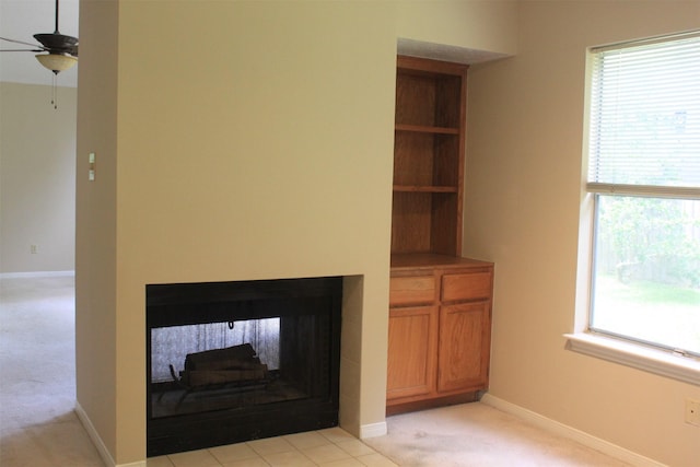 unfurnished living room with light colored carpet, baseboards, and a ceiling fan