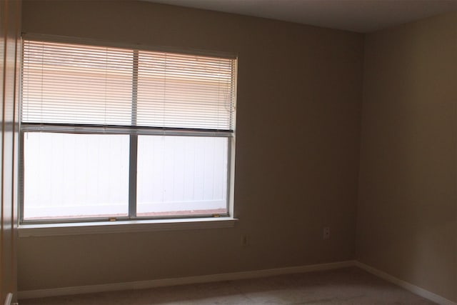 carpeted empty room with baseboards