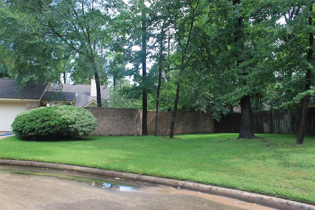 view of yard featuring fence and a garage