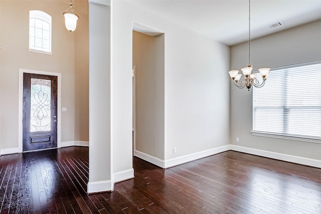 entryway featuring a chandelier, hardwood / wood-style floors, baseboards, and visible vents