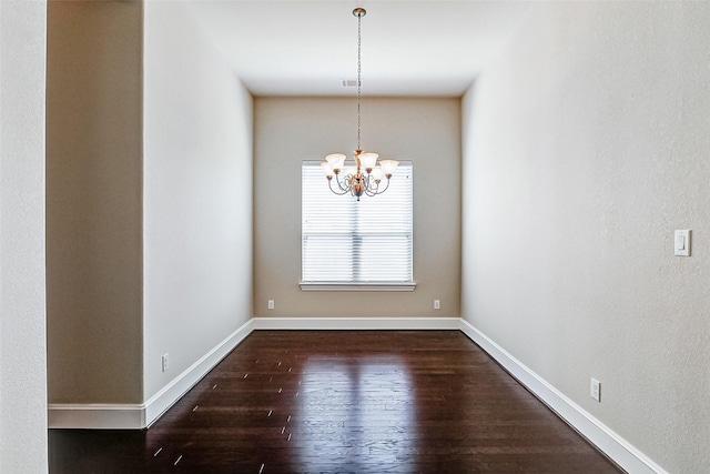 unfurnished dining area featuring visible vents, baseboards, an inviting chandelier, and dark wood-style floors