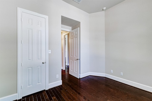unfurnished bedroom with baseboards, visible vents, and hardwood / wood-style flooring