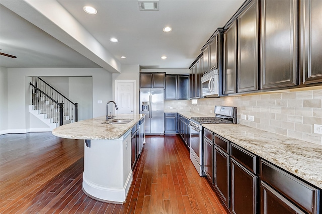 kitchen featuring stainless steel appliances, dark wood-type flooring, visible vents, and a sink