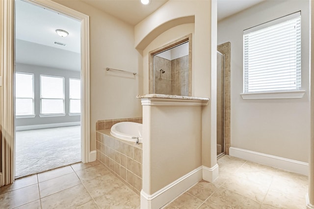 bathroom with a tile shower, a garden tub, baseboards, and tile patterned flooring