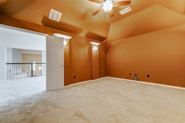carpeted spare room with visible vents, baseboards, vaulted ceiling, and ceiling fan