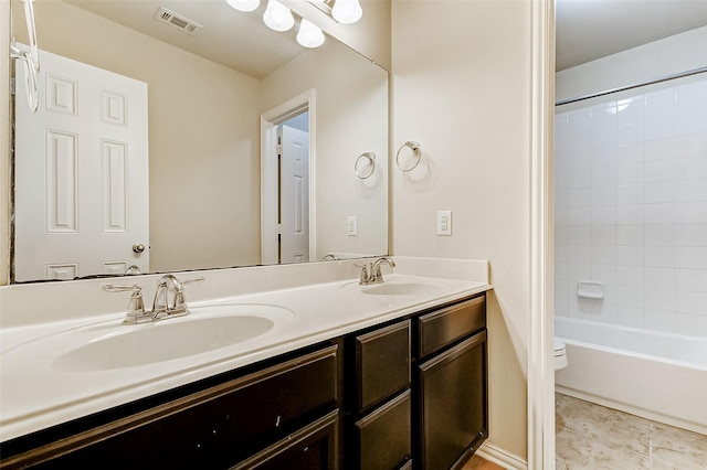 full bathroom with toilet, double vanity, a sink, and visible vents