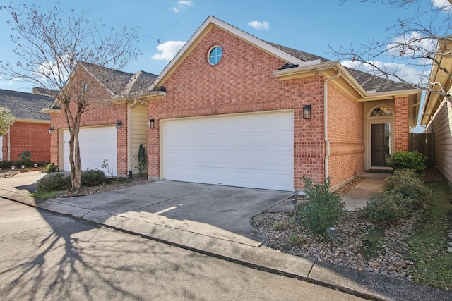 view of front of home featuring a shingled roof, brick siding, driveway, and an attached garage