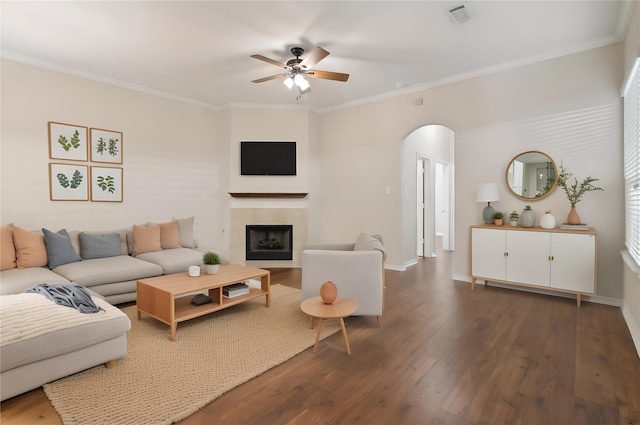 living area with visible vents, arched walkways, ornamental molding, ceiling fan, and wood finished floors