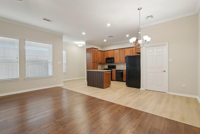 kitchen with light wood-style flooring, visible vents, black appliances, a chandelier, and open floor plan