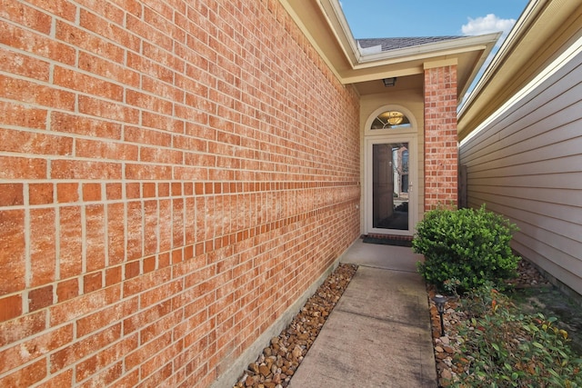 entrance to property featuring brick siding
