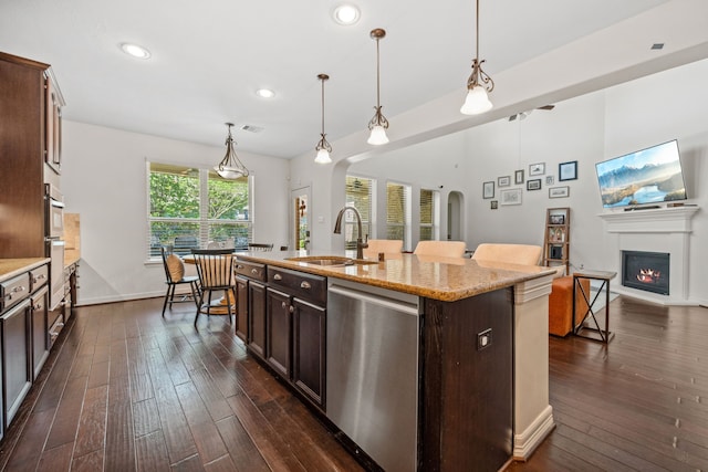kitchen with arched walkways, dishwasher, a sink, and dark wood-style floors