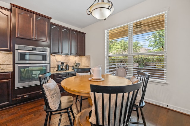 dining room featuring dark wood-style flooring and baseboards