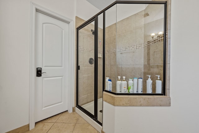full bath with a shower stall and tile patterned flooring