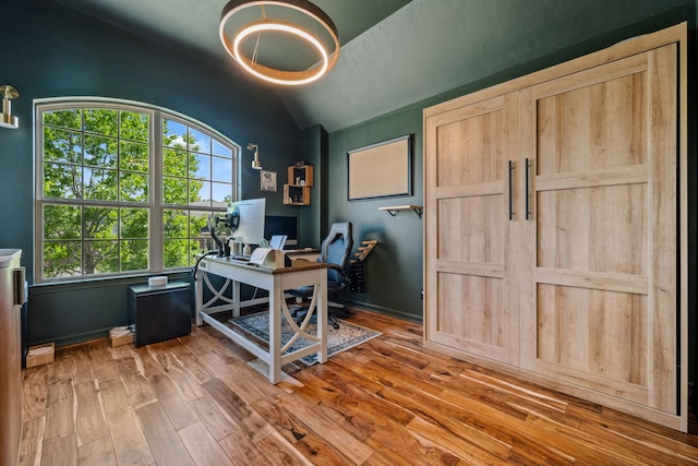 home office with a healthy amount of sunlight, baseboards, vaulted ceiling, and wood finished floors