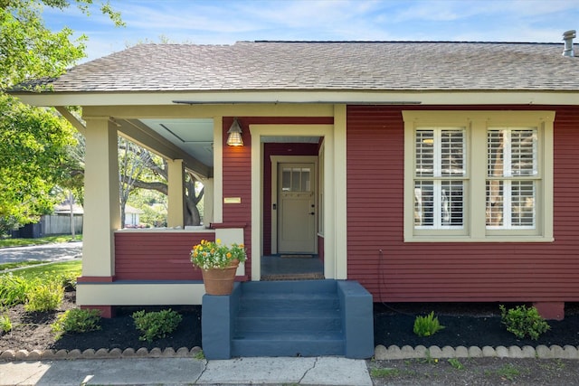 719 Key St, Houston, TX 77009 - doorway to property featuring roof with shingles and covered porch