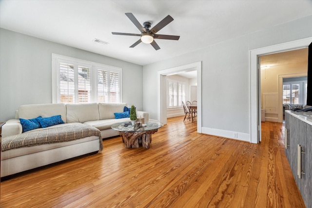 719 Key St, Houston, TX 77009 - living area featuring plenty of natural light, light wood-style floors, ceiling fan, and baseboards