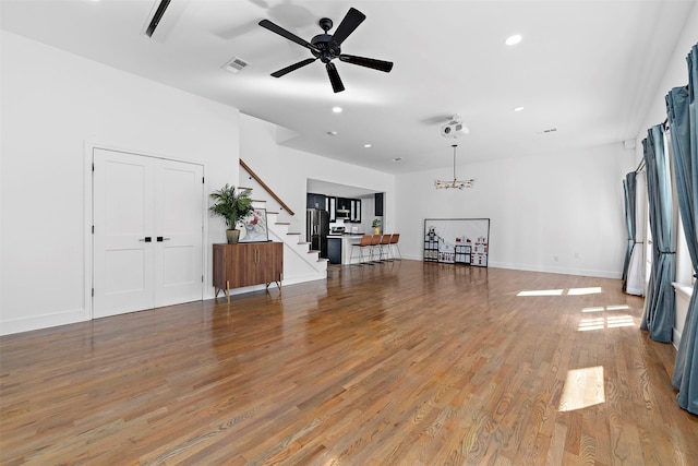 unfurnished living room with light wood-type flooring, recessed lighting, stairs, visible vents, and ceiling fan