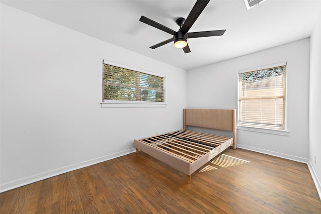 unfurnished bedroom featuring visible vents, baseboards, and wood finished floors